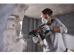 Man using a PARKSIDE PERFORMANCE® 20V Cordless Hammer Drill to break through a wall.