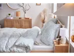 Floral bedding, bedside table, and modern lamps.