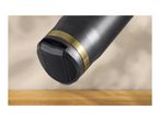 Close-up of a black travel mug with a gold band, resting on a wooden surface.