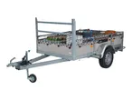 A gray metal utility trailer with a cargo net securing various items.