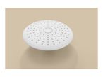 White round shower head with numerous nozzles on a beige background.