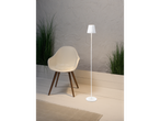 Moderne witte staande lamp en stoel met wollen kussen.