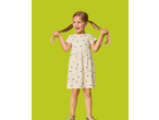 A young girl in a cream dress with black hearts, holding her pigtails, on a lime green background.