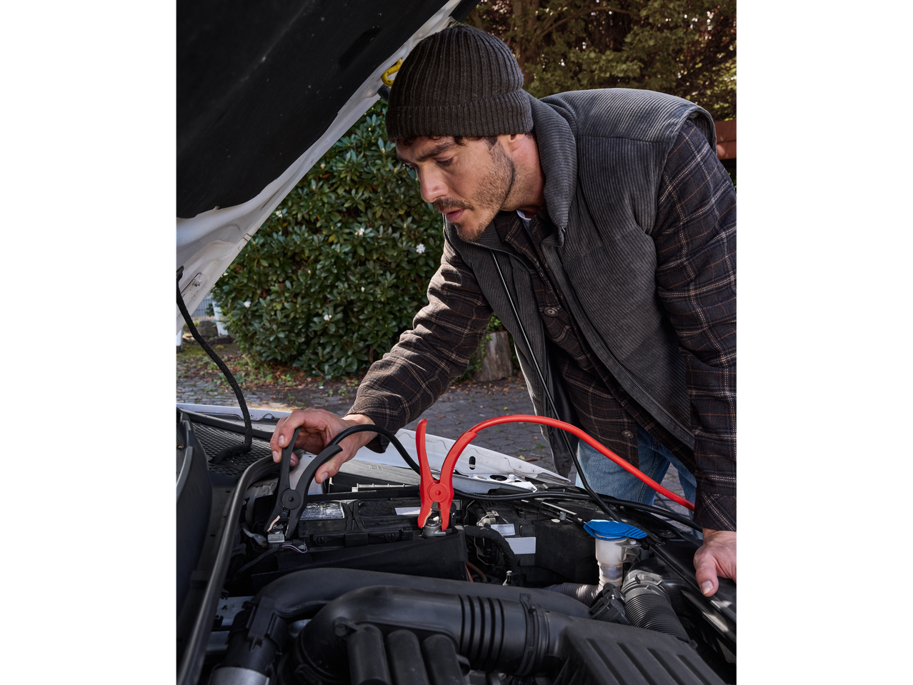 Мъж използва кабели за стартиране Ultimate Speed® за запалване на кола.