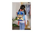 Child wearing a blue backpack with a cartoon dog design, standing in front of a clothes rack.