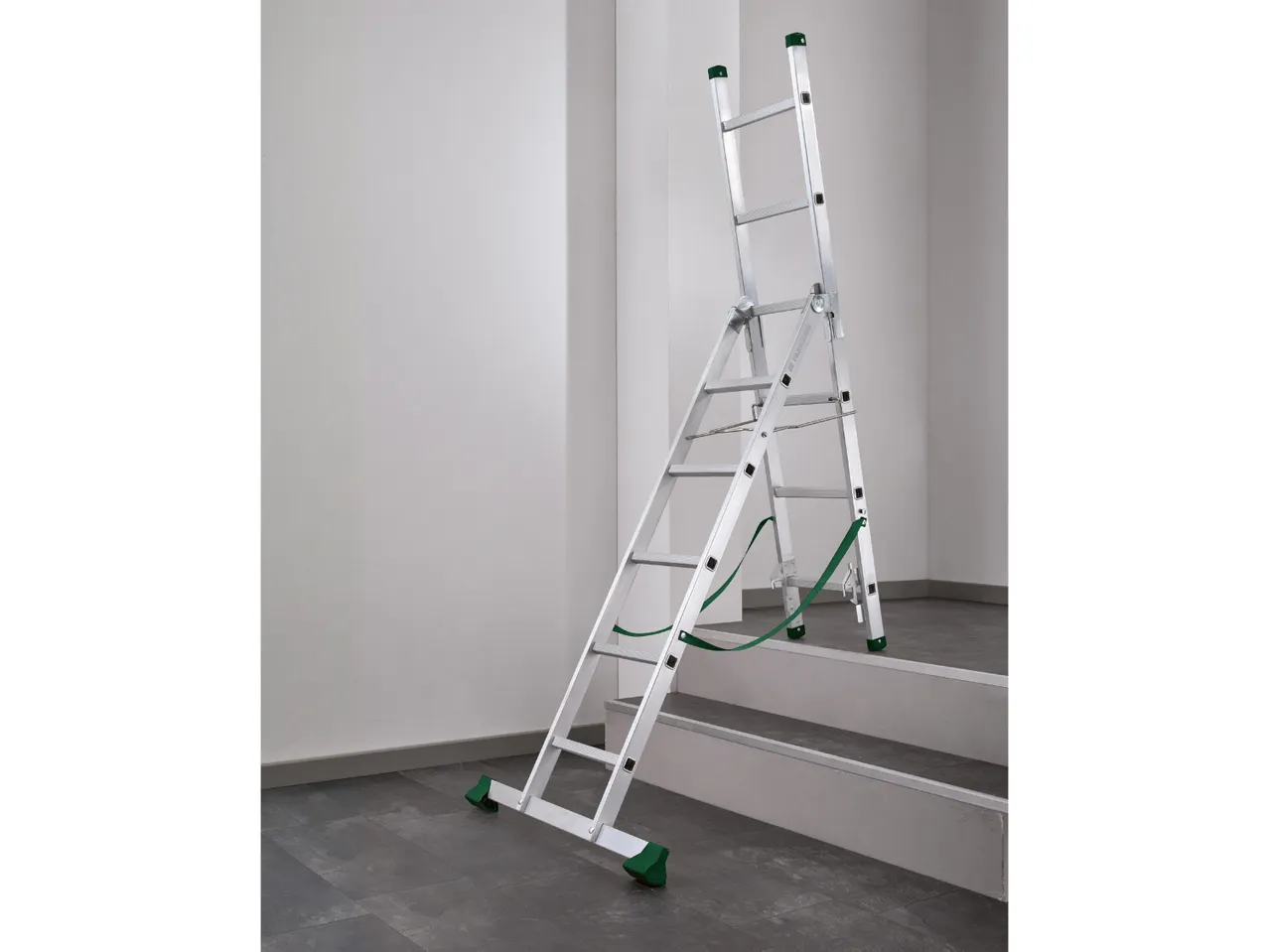 Multi-purpose ladder set up on stairs, with green safety straps and feet.