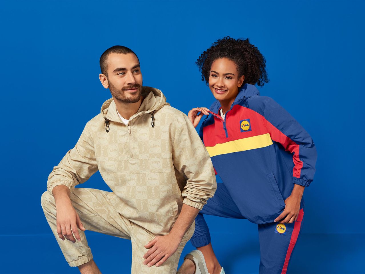 Lidl márkájú sportruházatot viselő fiatal pár egy kék háttér előtt.