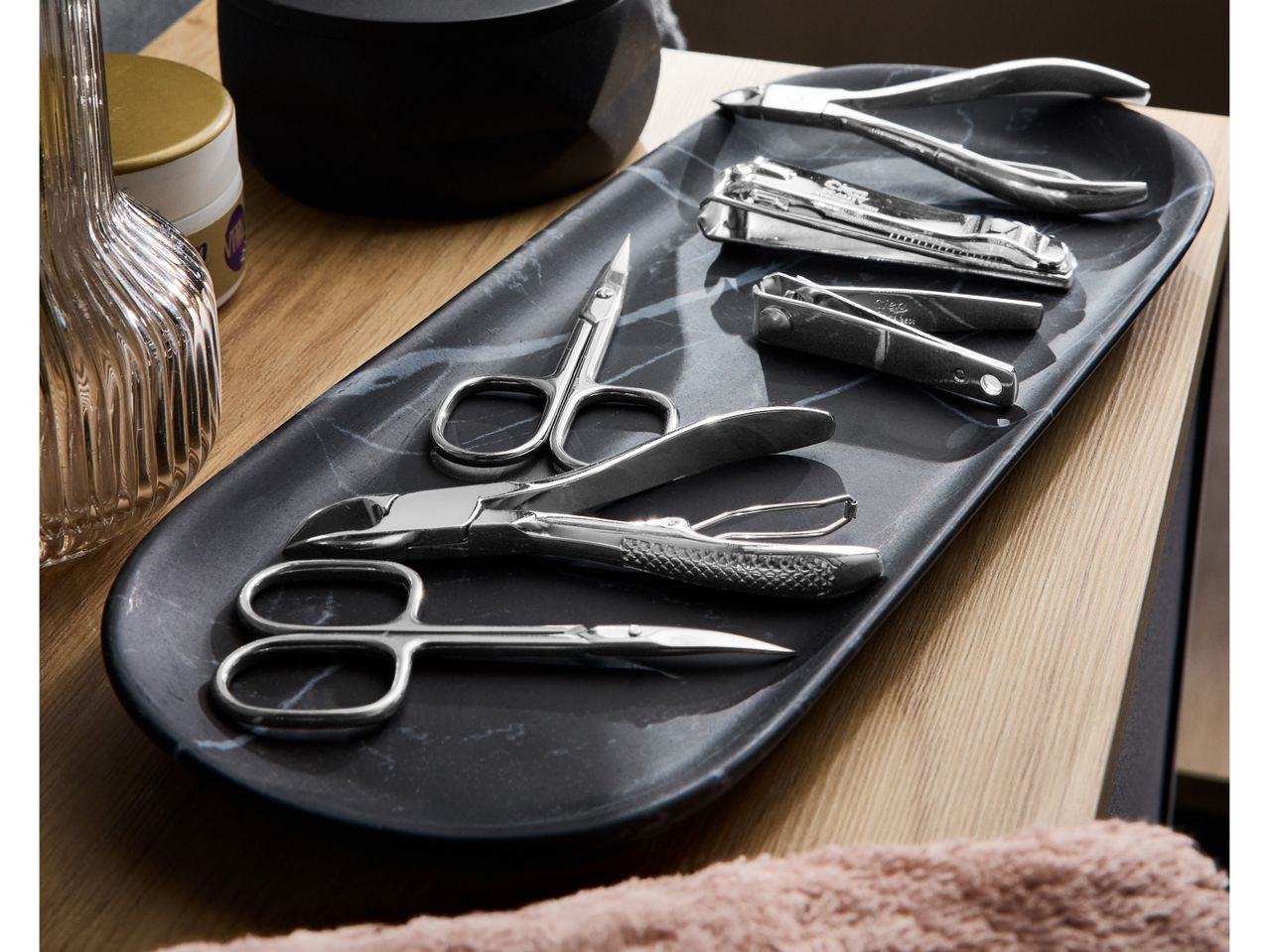 Manicure set with various tools on a black marble tray.