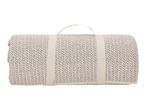 Rolled-up cream-colored knitted picnic blanket with carrying straps