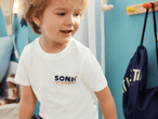 Kleines Kind trägt ein weißes SONN T-Shirt.