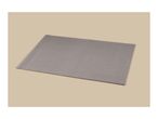 Grey ribbed placemat on a beige background.