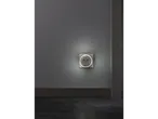 A wall-mounted USB charger with an illuminated ring, casting a glow on a dark gray wall.