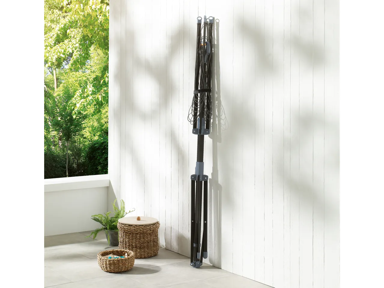 An outdoor clothes dryer with baskets and plants.