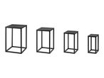 Set of four black metal nesting display stands in graduated sizes.