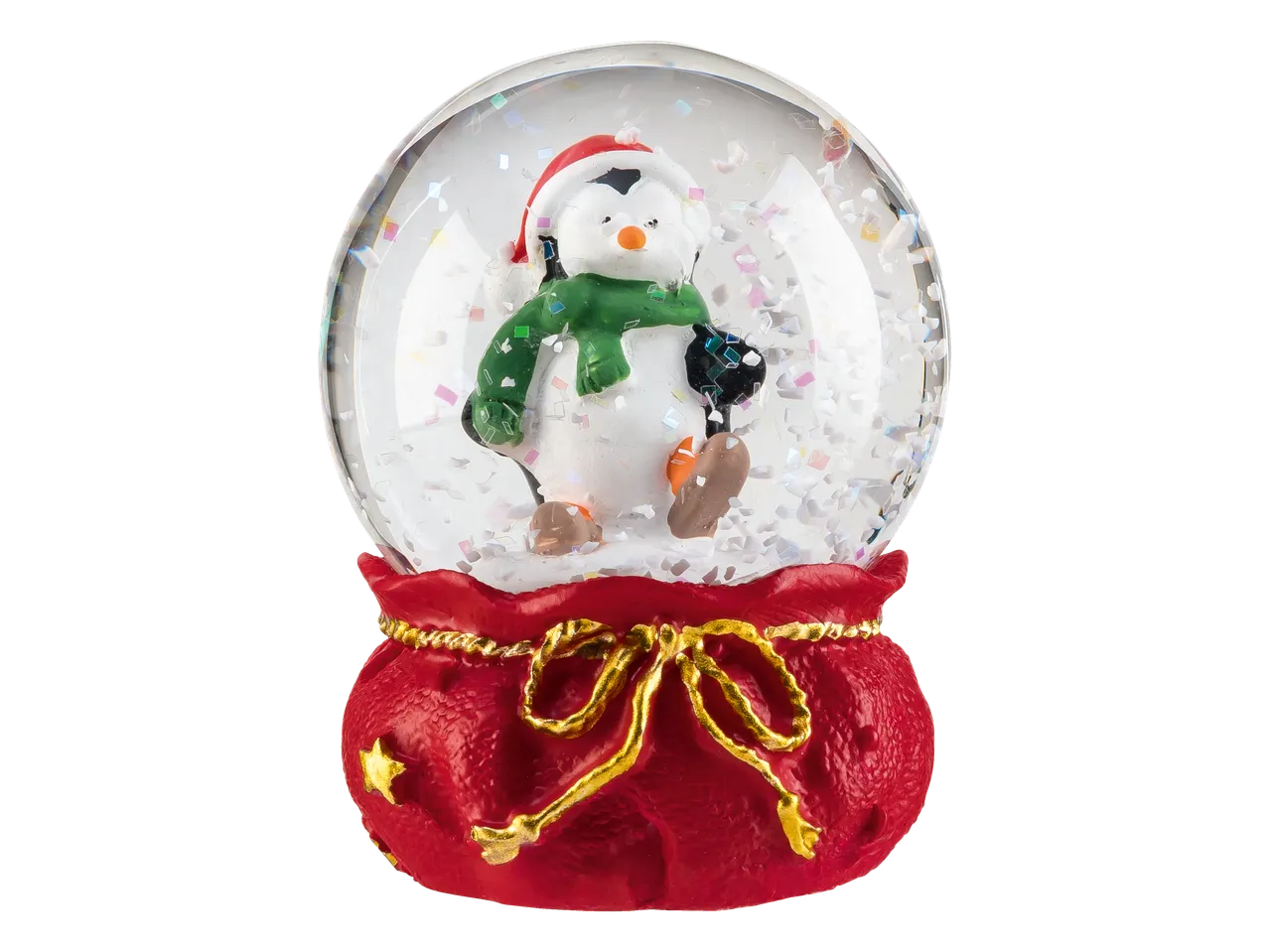 Sniega bumba ar pingvīnu Ziemassvētku cepurē un šallē, uz sarkana maisa formas pamatnes