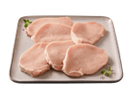 Rohe Schweinekoteletts auf einer grauen Platte, garniert mit Kräutern und Gewürzen.