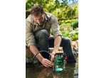 Man connecting a hose to a submersible pump in a pond.