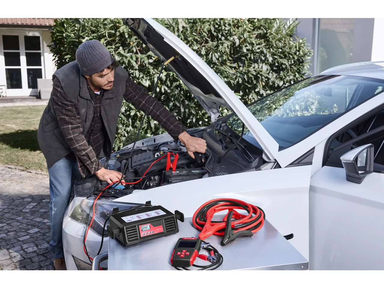 Man using ULTIMATE SPEED® Car Battery Charger to jump-start a car.