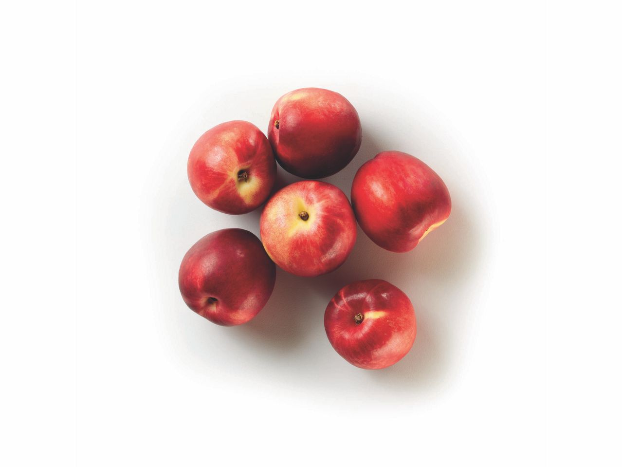 Six ripe nectarines arranged on a white background.