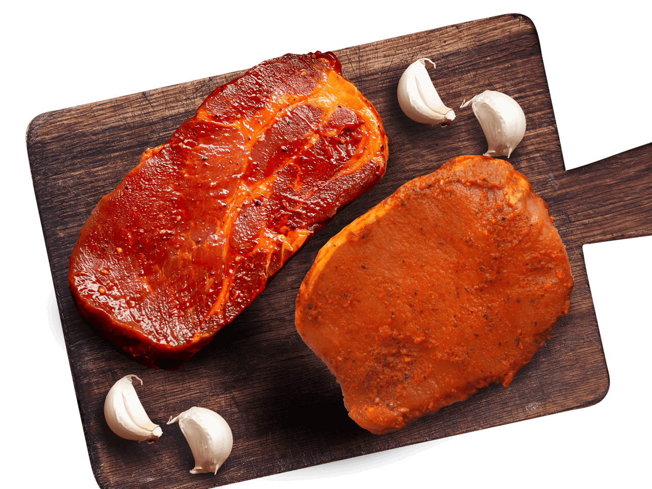 Marinierte Steaks auf einem Holzbrett mit Knoblauch.