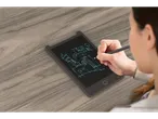 A woman sketches a building design on a black LCD writing tablet using a stylus.