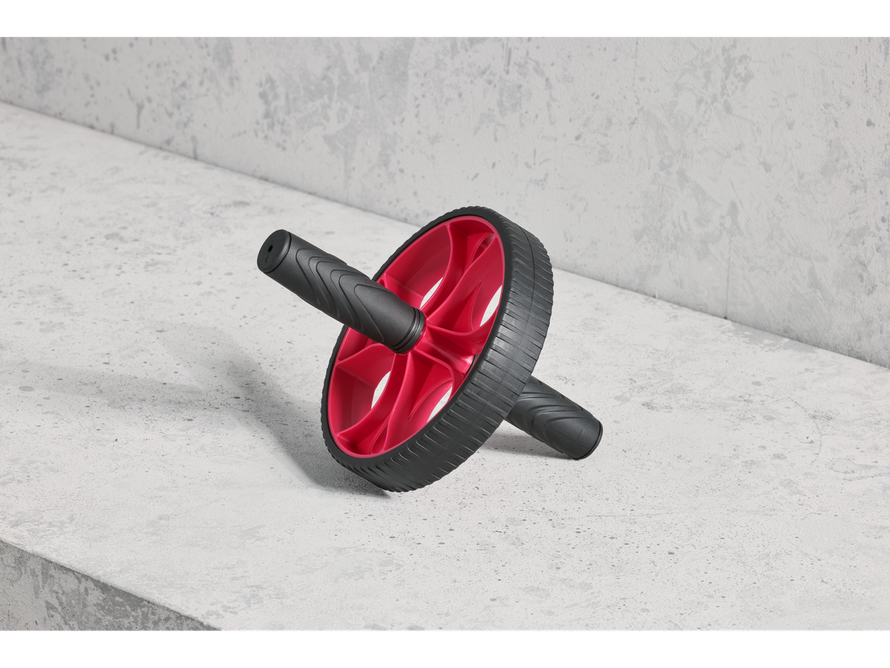 Crivit ab roller with red wheel and black handles on a concrete surface