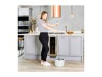 Woman cleaning kitchen floor with a mop and bucket, modern kitchen with grey cabinets.