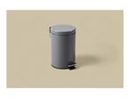 Grey pedal bin with a round lid and a black foot pedal on a beige background