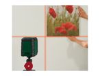 Laser level projecting crosshairs on a wall where a person is hanging a picture.