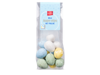 Een zakje melkdragee-eitjes met praliné in verschillende pastelkleuren, met Fairtrade Cocoa logo.