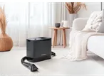 Aspirator fără fir Silvercrest® pentru tapițerie și covoare într-o cameră luminoasă cu canapea și plante.