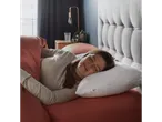 A woman sleeps peacefully on a Tempur-Pedic pillow in a cozy bedroom.