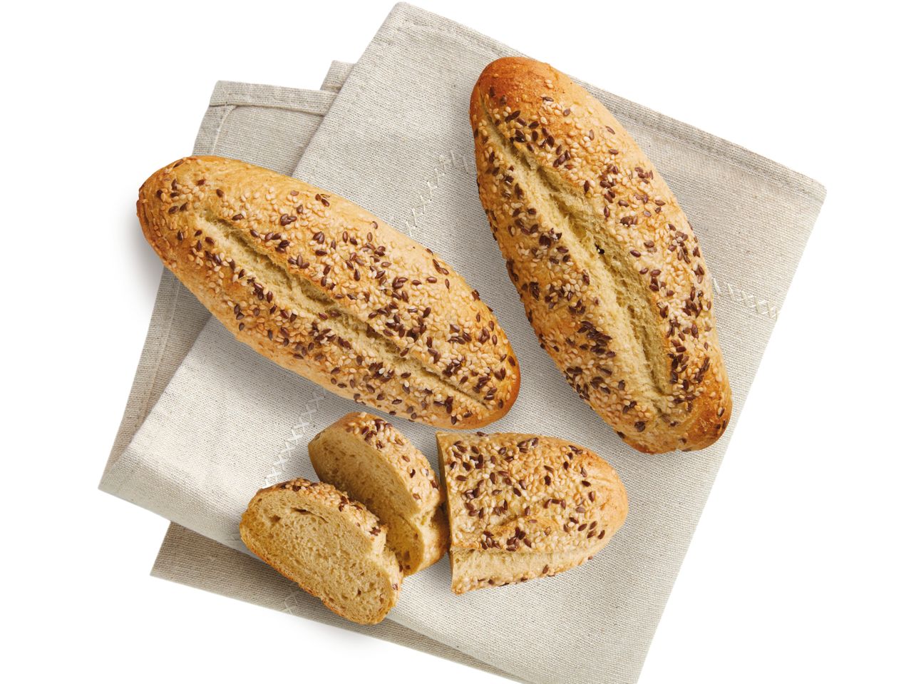 Sesam- und Saatenbrötchen auf einem Leinen-Tischtuch.