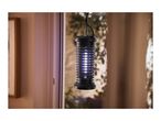 An electric insect killer with blue light hanging in front of a window.