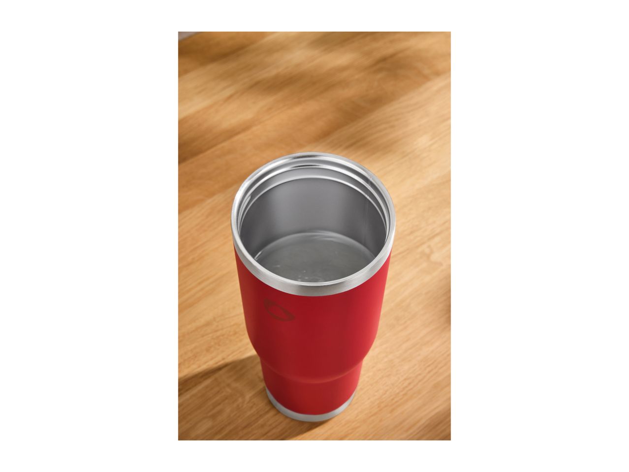 Red insulated tumbler on a wooden surface