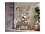 Bathroom with a wooden ladder shelf holding towels and toiletries, a hanging plant, and a shower.