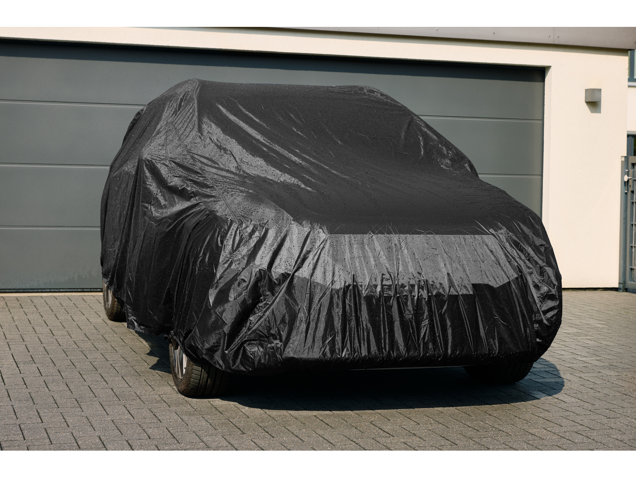 ULTIMATE SPEED® Full Car Cover, black, protecting a car parked on a paved driveway.
