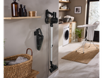 Aspirador de mão Silvercrest® Aku e aspirador vertical montados na parede de uma lavandaria.