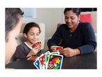 Family playing a card game at a table, with various cards visible.