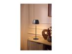 Modern black table lamp on a wooden sideboard next to decorative vases.