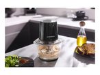 Food processor with hummus, olive oil, bread, and spices on a kitchen counter.