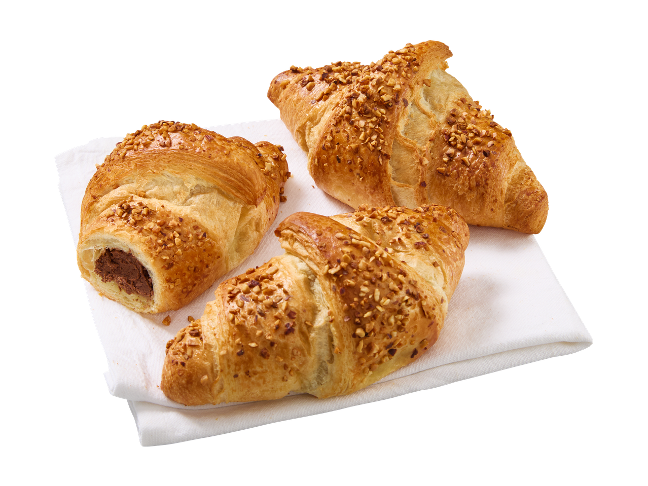 Kolme pähkinäkuorrutettua croissantia valkoisella lautasliinalla, yksi suklaatäytteellä.