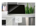 Laptop on a desk with a white power strip attached underneath, plugged into a cable.