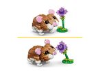 Two identical images of a brown and white toy hamster looking at a purple flower.