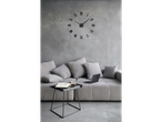 Relógio de parede criativo Auriol® numa sala de estar moderna com sofá e mesa de centro.