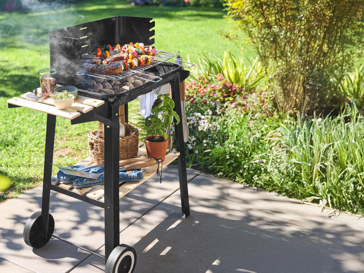 Kerti grill húsokkal és zöldségekkel, oldalsó asztalokkal és tárolópolccal.
