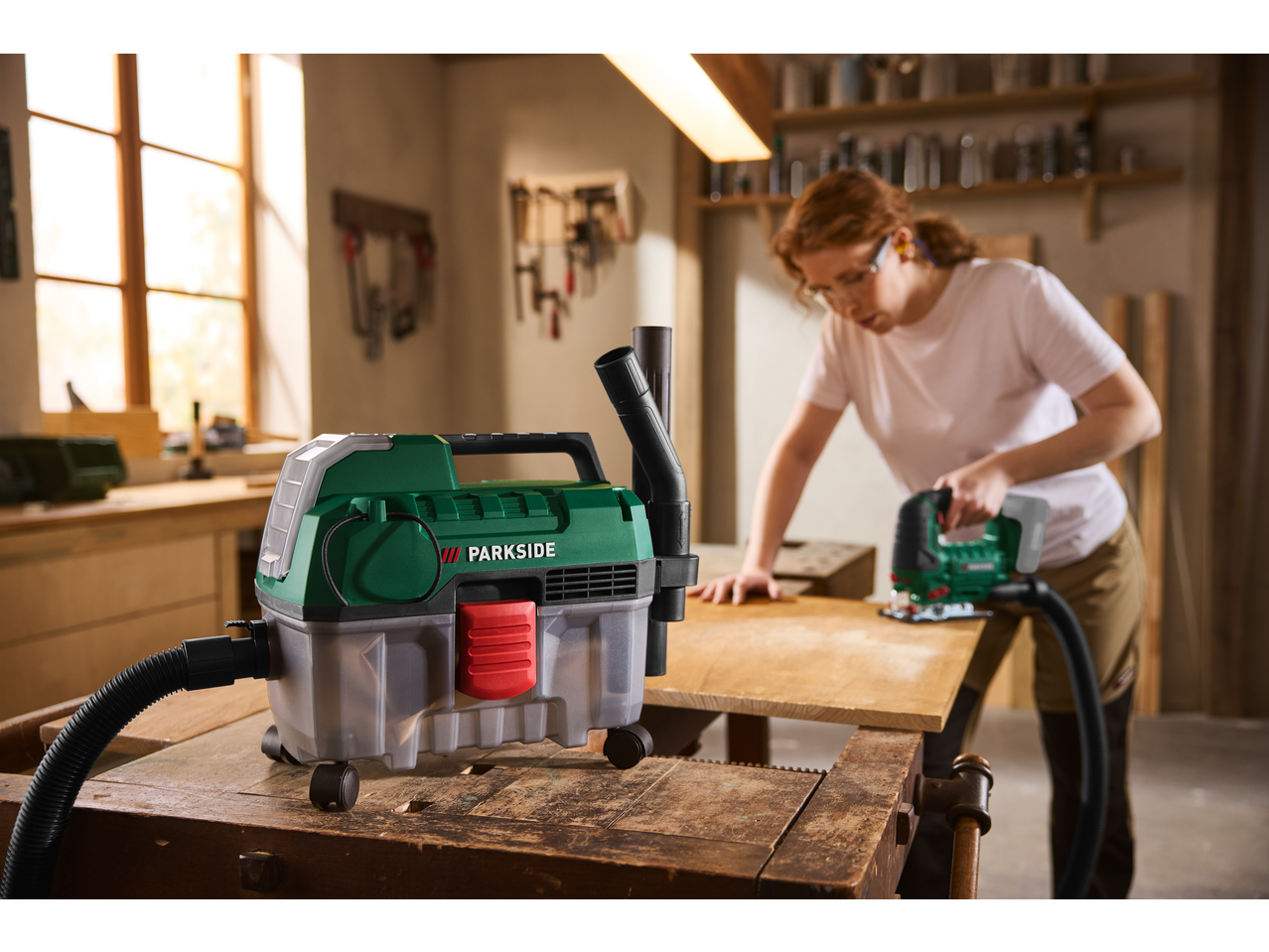PARKSIDE® 20V Cordless Wet and Dry Vacuum Cleaner connected to a jigsaw in a workshop.