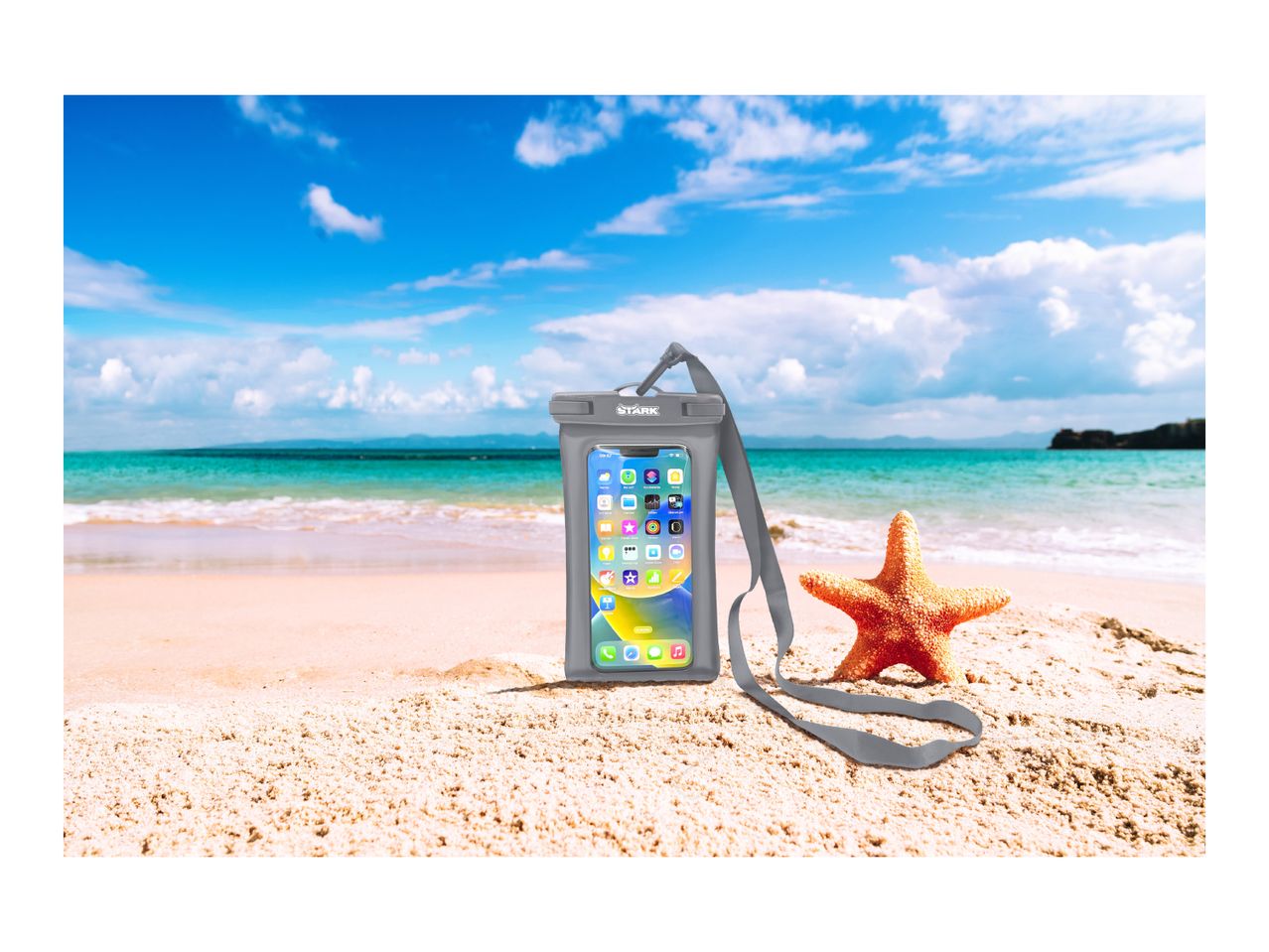 Waterproof phone pouch with a smartphone on a sandy beach with a starfish.