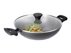 Black wok with a glass lid, filled with cooked vegetables.