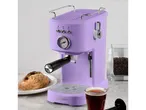 A lavender-colored retro-style espresso machine sits on a countertop next to a pastry and a cup of coffee.
